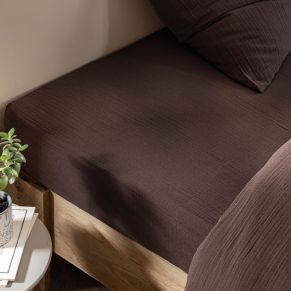 Drap housse gaze de coton marron dans une chambre à l'ambiance naturelle et chaleureuse