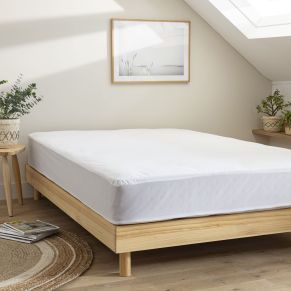Protège matelas en coton bio imperméable posé sur un lit, ambiance douce et naturelle