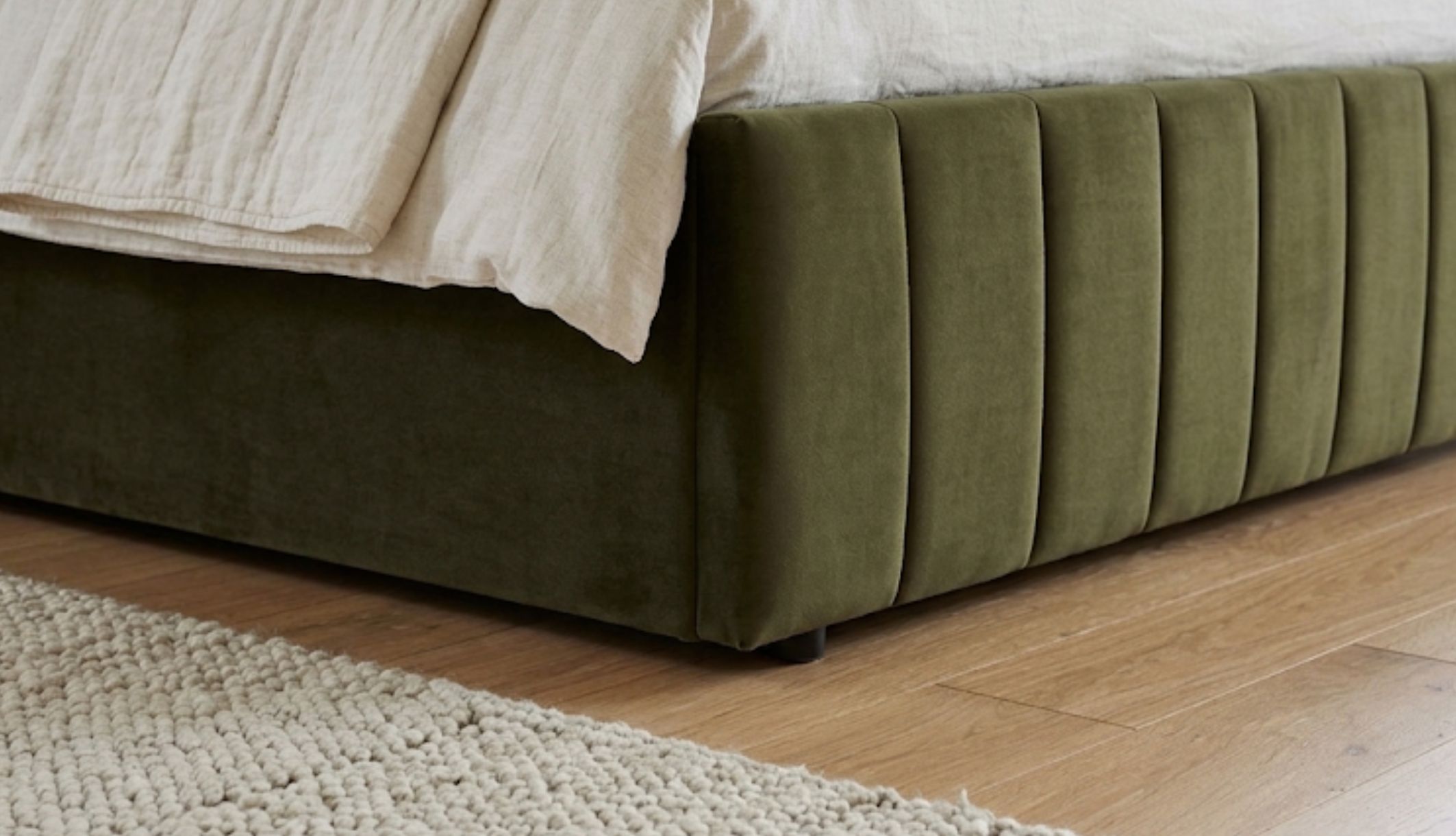 Zoom sur le bas du lit coffre en velours avec les pieds en PVC 